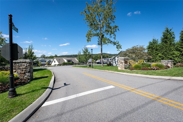 view of street featuring a residential view, curbs, and street lights