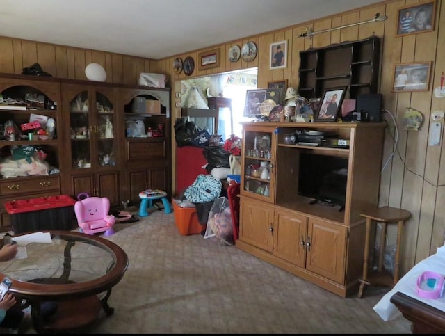 living area featuring carpet floors and wood walls