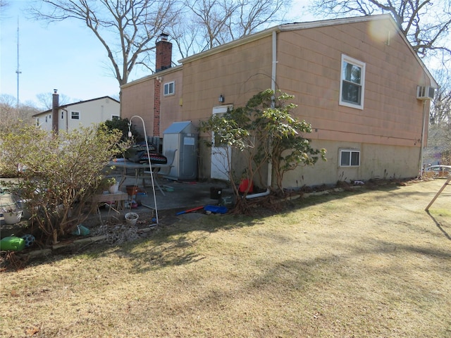 rear view of property with a yard and a chimney