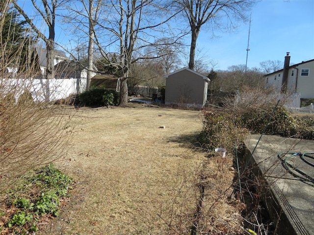 view of yard featuring an outbuilding, fence, and a storage unit