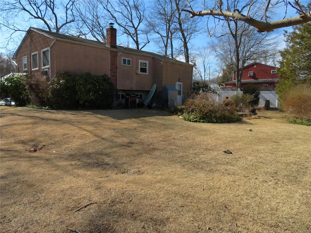 exterior space with a yard and a chimney