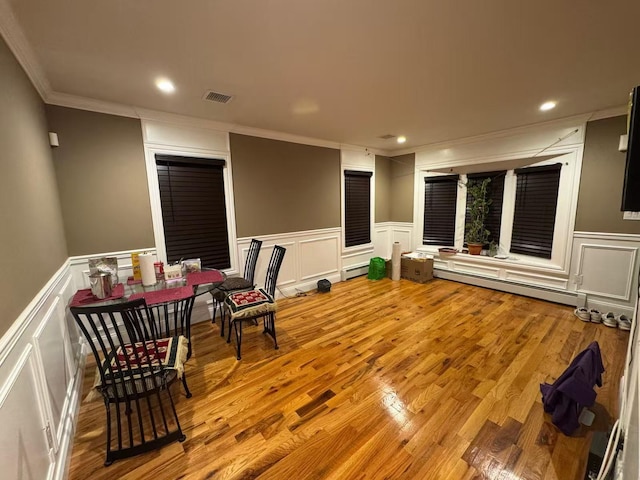 interior space featuring crown molding, recessed lighting, visible vents, baseboard heating, and wood finished floors