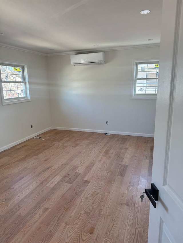 spare room featuring recessed lighting, wood finished floors, baseboards, a wall mounted air conditioner, and crown molding