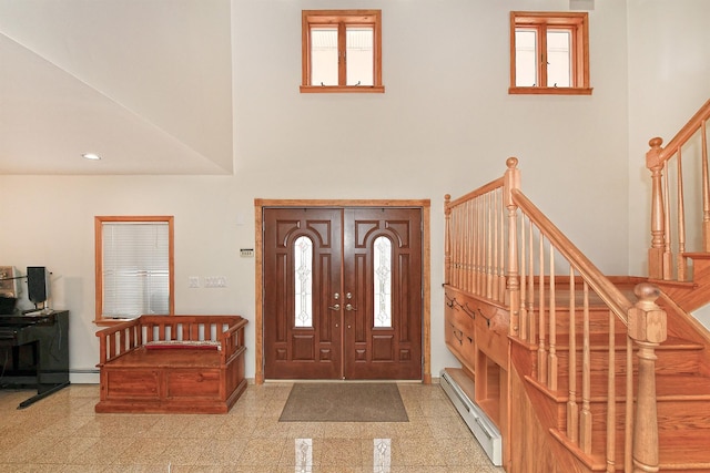 entryway featuring a baseboard heating unit, a high ceiling, granite finish floor, baseboards, and stairway