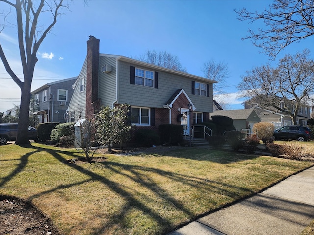 colonial-style house featuring a front yard, brick siding, and a chimney