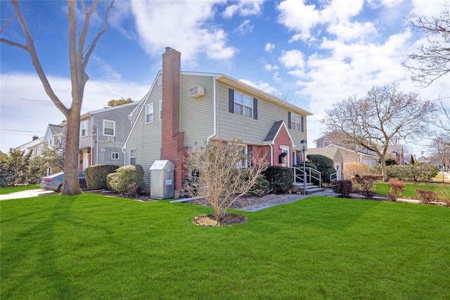 back of property with a yard, brick siding, and a chimney