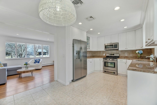 4645 Rocky Point Rd, East Marion, NY 11939 - kitchen featuring appliances with stainless steel finishes, a sink, light tile patterned floors, a baseboard radiator, and decorative backsplash