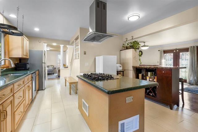 kitchen featuring decorative columns, freestanding refrigerator, extractor fan, stainless steel dishwasher, and a sink