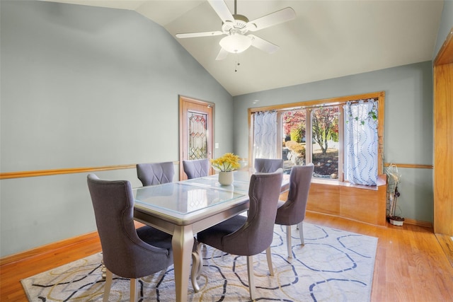 dining room featuring vaulted ceiling, ceiling fan, baseboards, and light wood-style floors