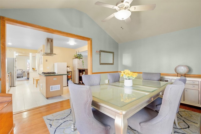 dining room featuring lofted ceiling, light wood-style floors, and a ceiling fan