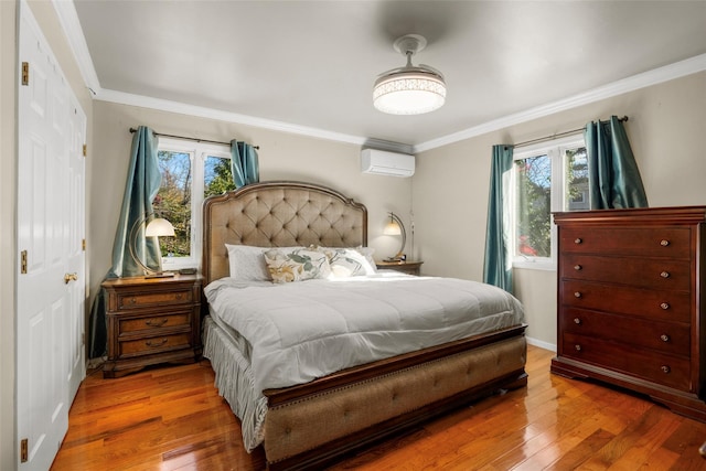 bedroom featuring ornamental molding, wood-type flooring, baseboards, and a wall mounted AC