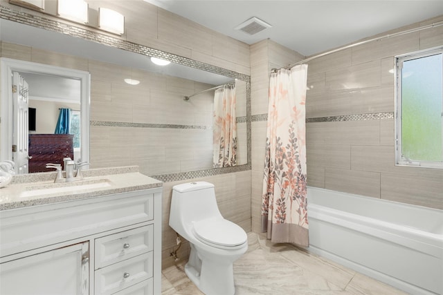 bathroom featuring visible vents, toilet, shower / bath combination with curtain, vanity, and tile walls