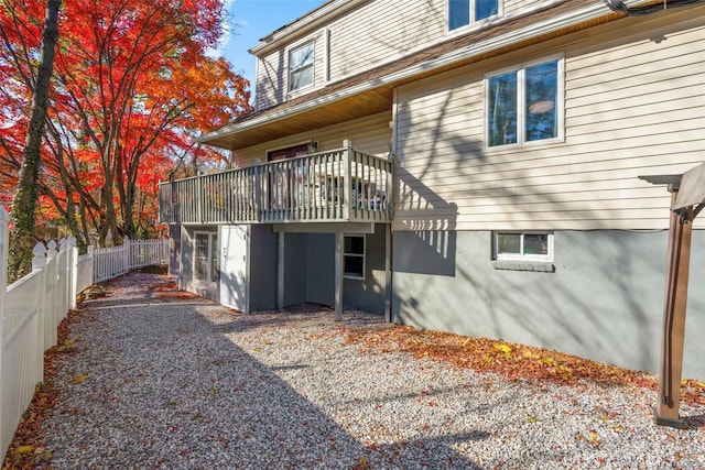 rear view of property featuring fence and a deck