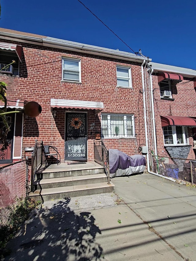 townhome / multi-family property with fence and brick siding