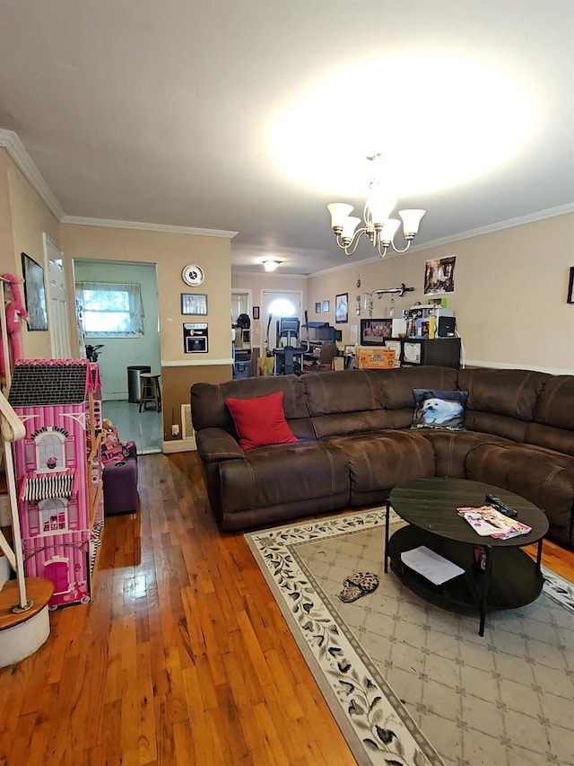 living area with wood-type flooring, crown molding, and a notable chandelier