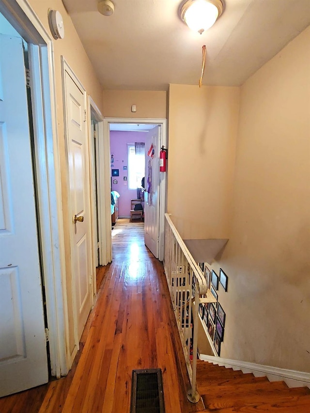 hallway featuring hardwood / wood-style floors and baseboards