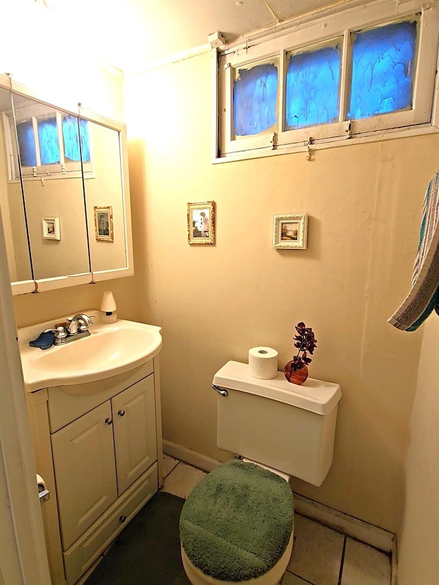 bathroom with baseboards, vanity, toilet, and tile patterned floors