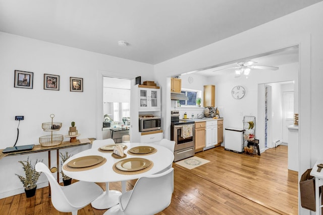 dining room featuring light wood-type flooring, ceiling fan, and a baseboard radiator