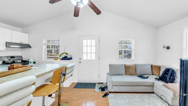 living room with vaulted ceiling with beams, a ceiling fan, and a healthy amount of sunlight