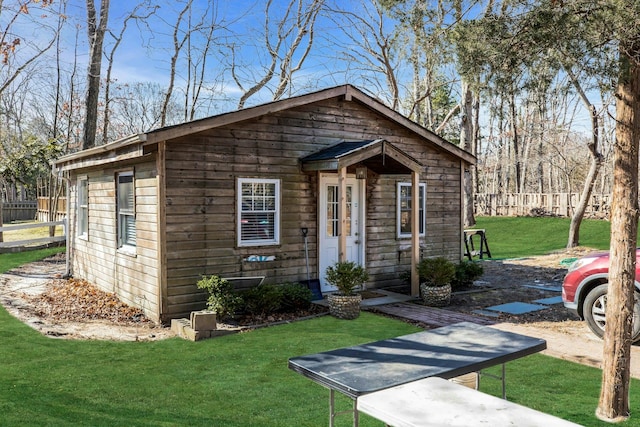 view of front of home featuring fence and a front lawn