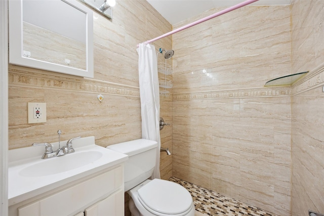 bathroom featuring a tile shower, vanity, and toilet