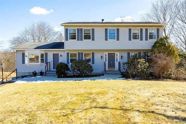 colonial-style house with entry steps and a front lawn