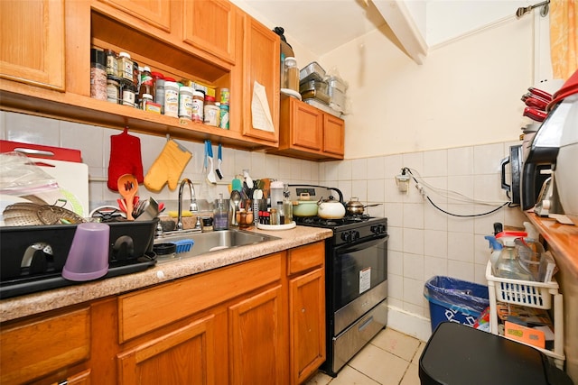 kitchen featuring light tile patterned floors, tile walls, light countertops, brown cabinets, and range with gas cooktop