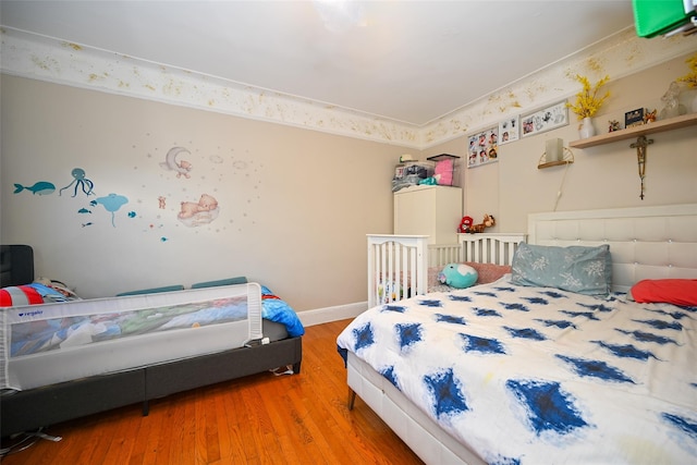 bedroom with wood finished floors and baseboards