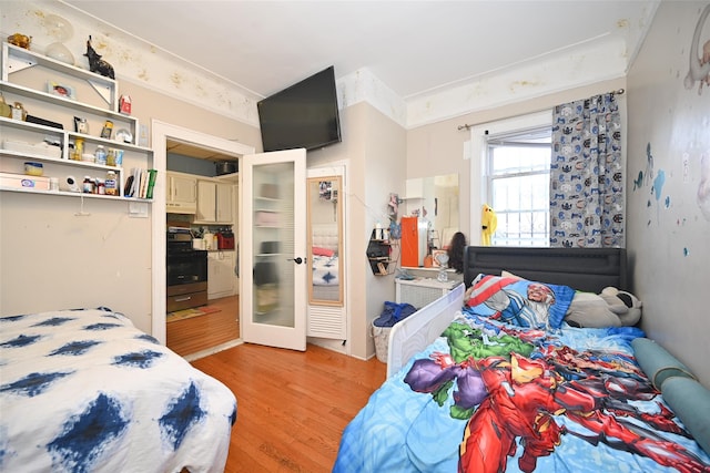 bedroom with french doors and light wood finished floors