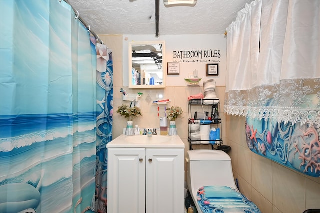 full bathroom with tile walls, a textured ceiling, a shower with shower curtain, and vanity