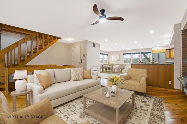 living room featuring a ceiling fan, recessed lighting, wood-type flooring, and stairs