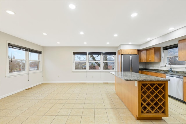 kitchen featuring light tile patterned floors, appliances with stainless steel finishes, a center island, a sink, and recessed lighting