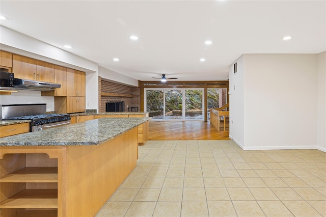 kitchen with under cabinet range hood, light stone counters, stainless steel appliances, and recessed lighting