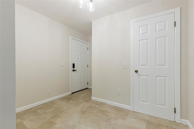 spare room with light tile patterned floors and baseboards