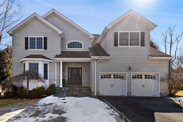 view of front of property featuring driveway, a shingled roof, and an attached garage