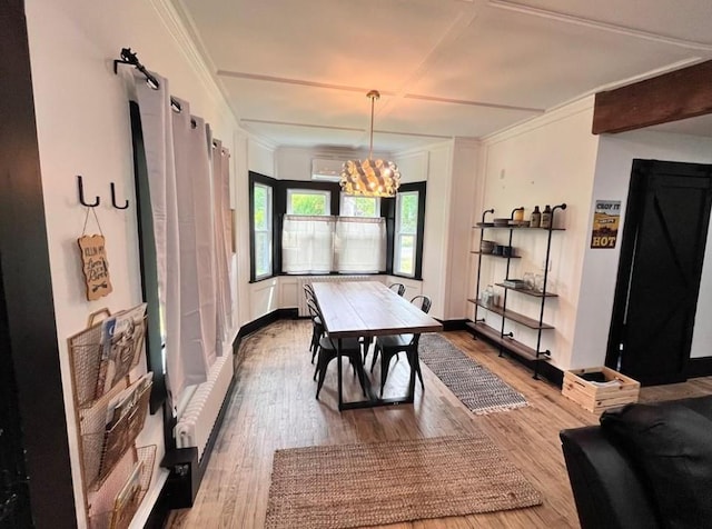 dining room featuring a notable chandelier, crown molding, and wood finished floors