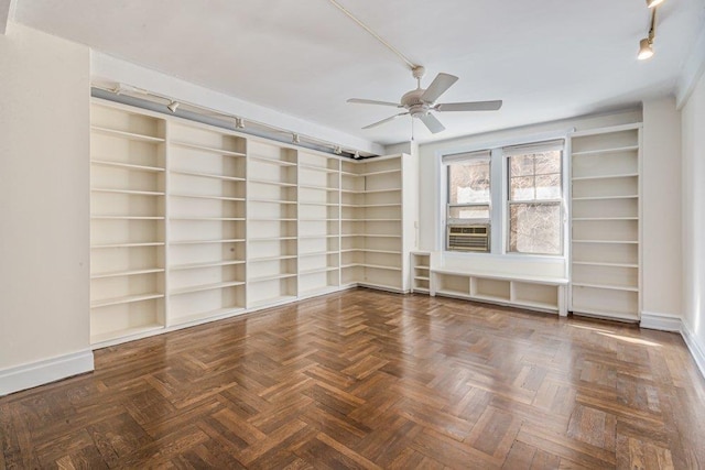 empty room featuring track lighting, a ceiling fan, and baseboards