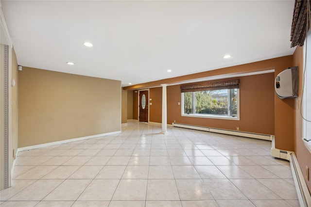 unfurnished room featuring decorative columns, recessed lighting, a baseboard heating unit, and light tile patterned flooring
