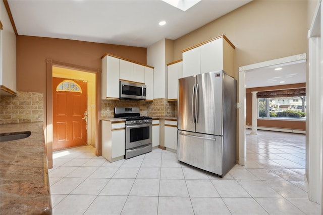 kitchen featuring tasteful backsplash, appliances with stainless steel finishes, white cabinets, and a baseboard radiator
