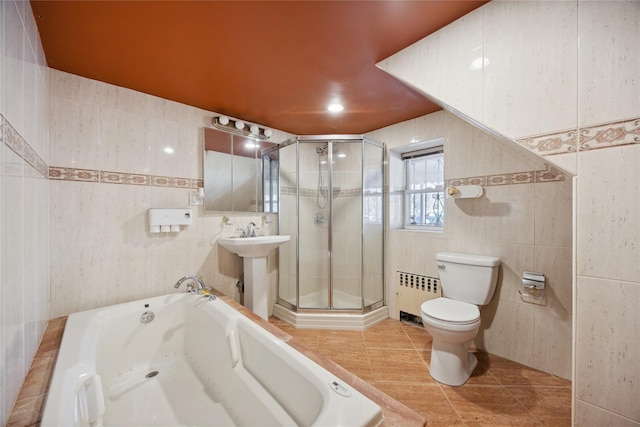 bathroom with toilet, a stall shower, radiator, and tile walls