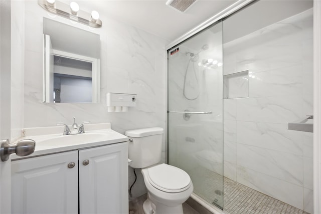 bathroom with vanity, a stall shower, toilet, visible vents, and tile walls