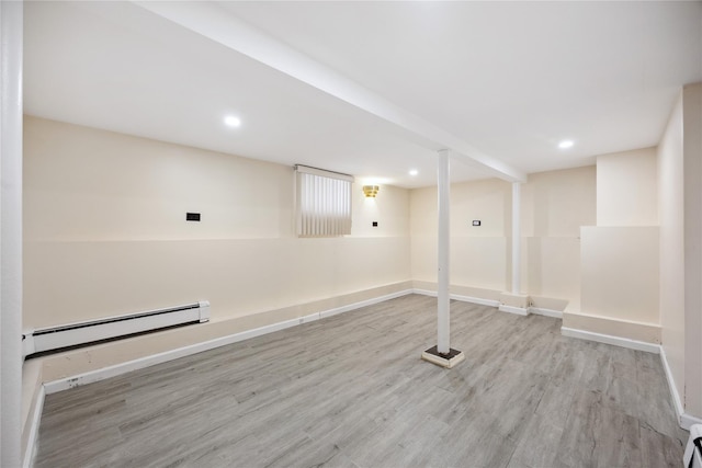 finished basement featuring a baseboard radiator, wood finished floors, baseboards, and recessed lighting
