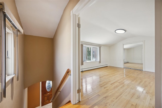 bonus room with light wood finished floors, a baseboard heating unit, and vaulted ceiling