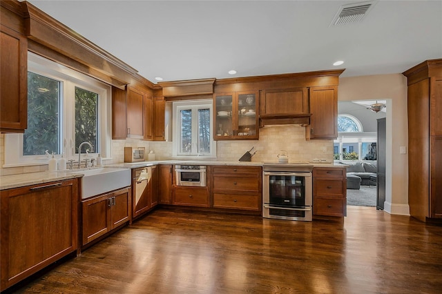 kitchen featuring electric stove, a sink, visible vents, and decorative backsplash