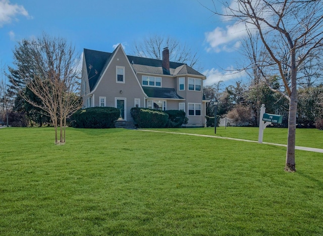 view of front of home featuring a front yard and a chimney