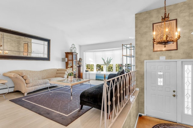 living area with light wood-style floors, a baseboard radiator, and an inviting chandelier