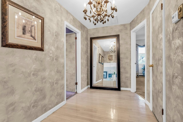 hallway featuring baseboards, hardwood / wood-style floors, and wallpapered walls