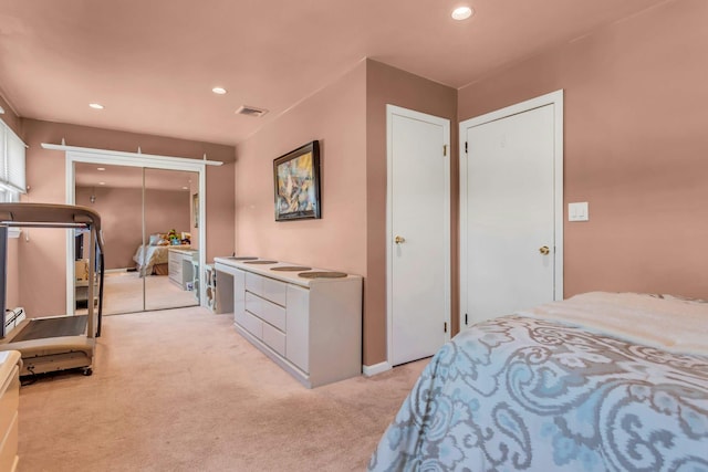 bedroom with recessed lighting, visible vents, a closet, and light colored carpet