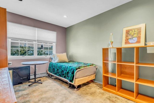 carpeted bedroom with baseboard heating and baseboards