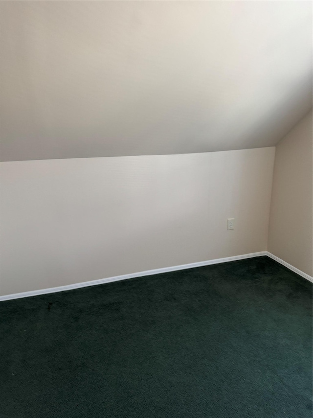 bonus room featuring lofted ceiling, baseboards, and dark carpet